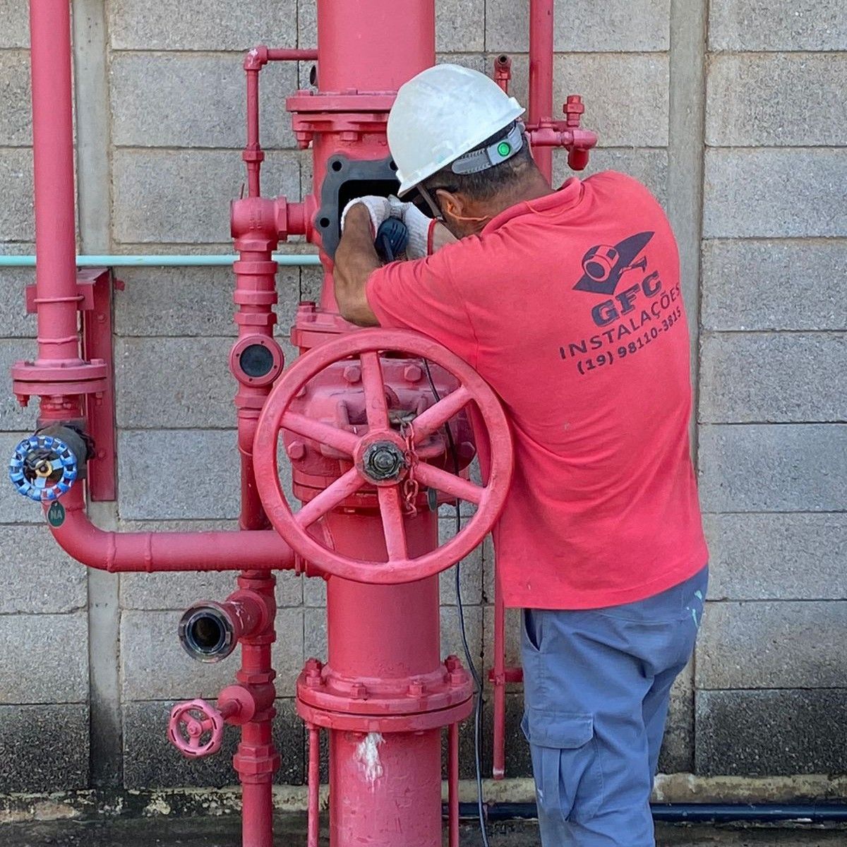 Técnico da GFC Instalações fazendo manutenção em uma válvula de governo e alarme